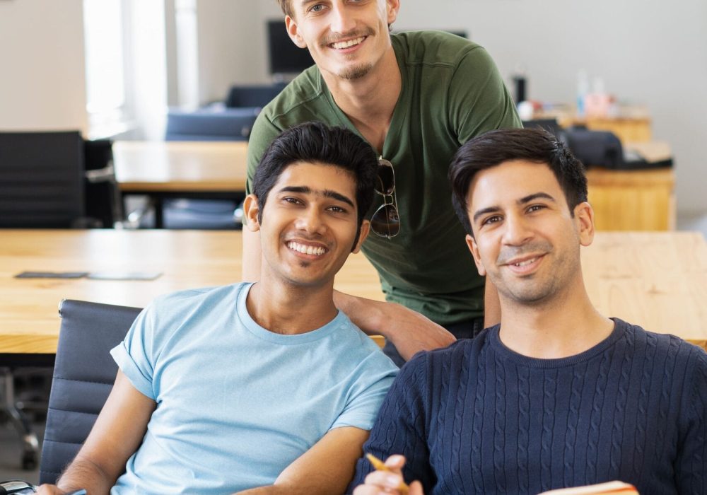three-happy-fellow-students-studying-looking-camera (1)