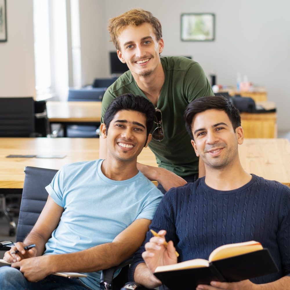 three-happy-fellow-students-studying-looking-camera (1)